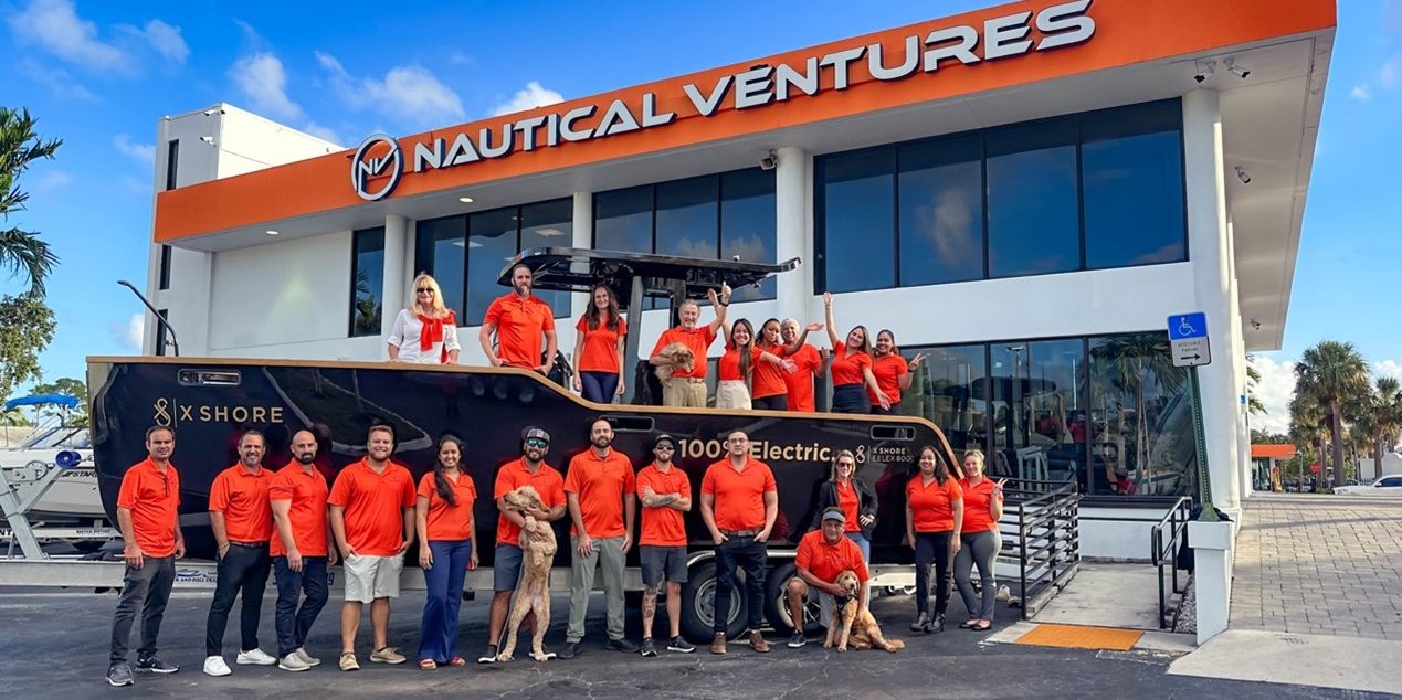 Nautical Ventures team poses with a new model from X-Shore Boats.
